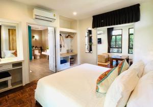 班克鲁特斯拉路恩度假村的一间带白色床的卧室和一间浴室