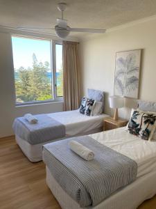 黄金海岸Oceania on Burleigh Beach的酒店客房设有两张床和窗户。