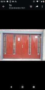 GualeguaychúDEPTO Familiar的窗户上方有一扇红色的门