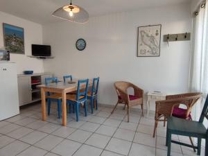 奥雷龙圣乔治Appartement Saint-Georges-d'Oléron, 2 pièces, 4 personnes - FR-1-246A-117的一间带桌椅和时钟的用餐室