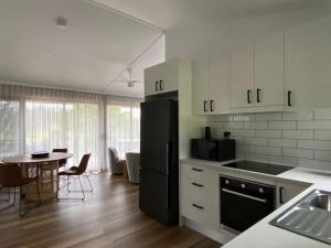 LimpinwoodSelah Valley Estate的厨房配有黑色冰箱和桌子