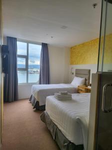 麦克坦Sempre Premier Inn - MACTAN AIRPORT HOTEL的酒店客房设有两张床和大窗户。