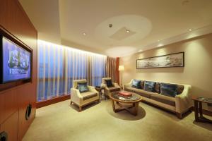 深圳兰赫美特酒店的客厅配有沙发、椅子和电视