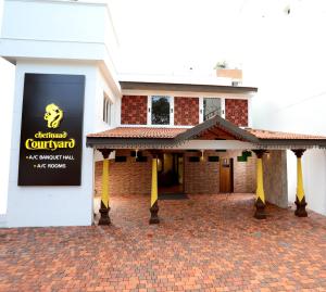 哥印拜陀Chetinaad Courtyard Gandhipuram by Centre Park的建筑的侧面有标志