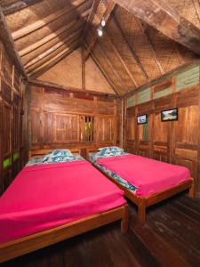 斯勒曼Villa Kampung Ayem Riverside的木制客房内的一间卧室配有两张床