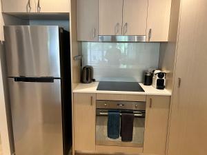 堪培拉Envy 11 Luxe 1BR Apt Braddon WiFi Netflix Wine Secure Parking Canberra的一间带不锈钢冰箱的小厨房