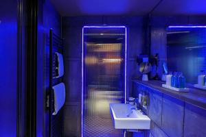 利兹The Bells - Luxury Serviced Apartments的浴室设有水槽和带蓝色灯光的淋浴。