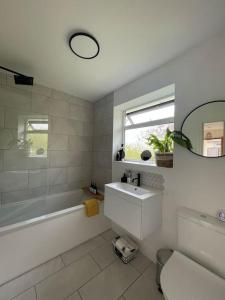 伯恩茅斯Modern, central bungalow with Luxury Hot tub的带浴缸、水槽和镜子的浴室