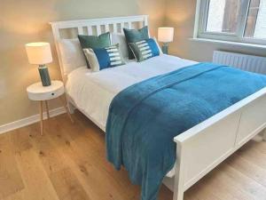 LettermacawardDonegal Beach Cottage with Sea Views, sleeps six的卧室配有一张带蓝色床单和枕头的大型白色床。