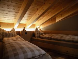 贝特默阿尔卑全景餐厅酒店 的配有木天花板的客房设有两张床。