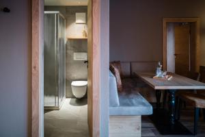 贝特默阿尔卑全景餐厅酒店 的一间带卫生间、水槽和桌子的浴室