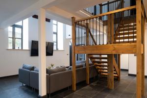 布莱奈费斯蒂尼奥格Finest Retreats - Capel Salem的带沙发和木制楼梯的客厅