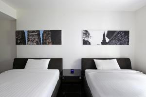 曼谷素坤逸S33精品酒店的两张睡床彼此相邻,位于一个房间里