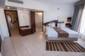 沙姆沙伊赫Sharming Inn Hotels - Couples and Families Only的一间带大床的卧室和一间浴室