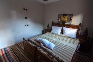伊姆利尔Berber Family Lodge的一间卧室配有一张木架大床