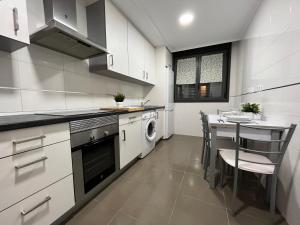 圣比森特德拉松谢拉Apartamento San Vicente de la Sonsierra Confort的厨房配有桌子和炉灶。 顶部烤箱