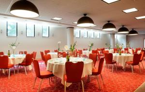 蒙彼利埃皇冠假日佩里尔峰库尔姆酒店的一间会议室,配有桌椅和灯光