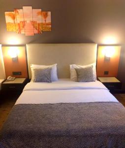 伊斯坦布尔ZEO HOTEL merter的一间卧室配有一张带两盏灯的大型白色床。