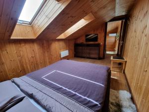 库尔迪加Saules Street Home的木制客房内的一间卧室,配有一张床