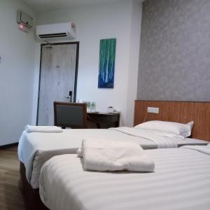 莎阿南拜斯达瑞138号酒店的一间设有两张床的房间,上面有白色的毛巾