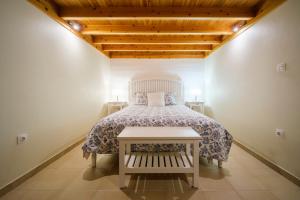 Terra AltaStone Home Casa do Caisinho Pico island的一间卧室配有一张带白色床罩的床
