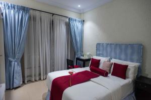 阿克拉The Ritzz Exclusive Guest House的卧室配有带红色枕头的大型白色床