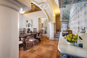波西塔诺Estate4home - Palazzo Crocione的厨房以及带桌椅的用餐室。