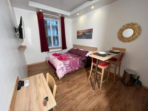 尼斯Residence Akantha的小房间设有一张床、一张桌子和一张书桌