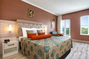 凯麦尔Orange County Kemer Family Only的酒店客房配有一张带橙色枕头的大床