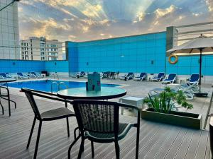 沙迦沙迦国敦大酒店的一个带桌椅的庭院和一个游泳池
