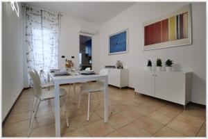 都灵[10 min metro] Palavela Suite的白色的用餐室配有白色的桌椅