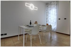 都灵[10 min metro] Palavela Suite的白色的用餐室配有白色的桌椅