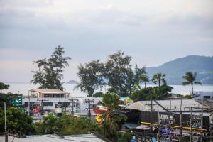 芭东海滩Rico's Patong Hotel的一群建筑,树木和水体