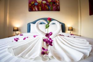 芭东海滩Rico's Patong Hotel的白色的床,花做的天鹅