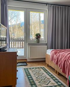 卡尔帕奇Willa RADosna的一间卧室设有一张床和一个阳台的窗户。