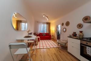 维也纳Cosy brand new Apartment的一间厨房和一间带红色沙发的客厅