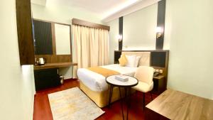迪拜Concorde Inn Hotel的酒店客房,配有床、桌子和椅子