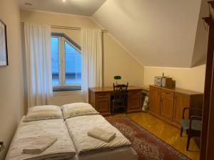 霍伊尼采Apartament u Gabi的一间卧室配有一张床、一张书桌和一个窗户。