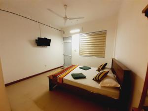 TalawatugodaRoyal Crown Residence的一间卧室配有一张床和一台电视
