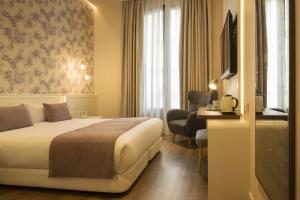巴塞罗那ICON Bcn的酒店客房配有一张床、一张书桌和一台电视。