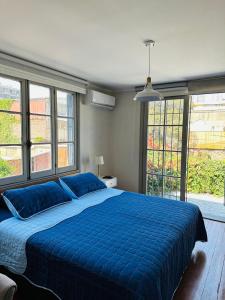 圣地亚哥Maktub Brasil - Hostal Boutique的一间卧室设有一张大蓝色的床和窗户。