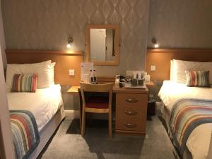 绍斯波特The Bowden Lodge的酒店客房配有两张床和一张带镜子的书桌