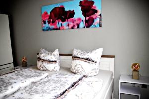 圣安德里斯伯格FeWo Sonja的一间卧室配有两张带枕头的床和墙上的绘画。