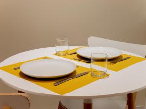 蒂耶里堡Le Lion - Plain-pied, WIFI, YT Premium - 2RFHomes的黄色餐巾纸上带板子和玻璃杯的白色桌子