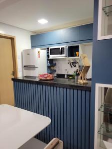 巴雷里尼亚斯Apartamento Condomínio Lençóis Confort的厨房配有微波炉和冰箱。