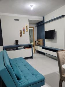 巴雷里尼亚斯Apartamento Condomínio Lençóis Confort的客厅配有蓝色的沙发和电视
