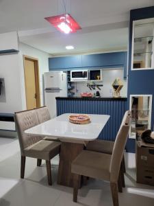 巴雷里尼亚斯Apartamento Condomínio Lençóis Confort的厨房配有白色的桌椅