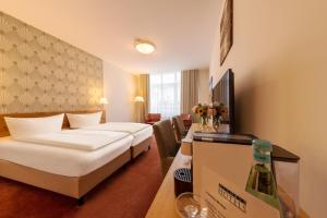 诺德奈诺德奈米歇尔斯海水浴酒店的酒店客房,设有两张床和一张鲜花桌。