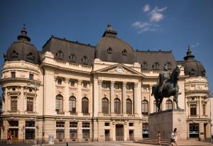 布加勒斯特塔尼亚 - 法兰克福酒店的一座大建筑,前面有雕像