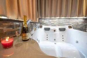 罗马Virtus Prestige - Rooms & Apartments的浴缸内的一瓶葡萄酒和两杯酒